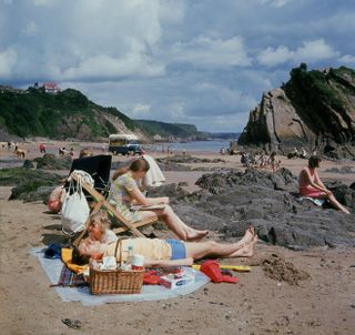 A family relaxing on Tenby beach, Wales.