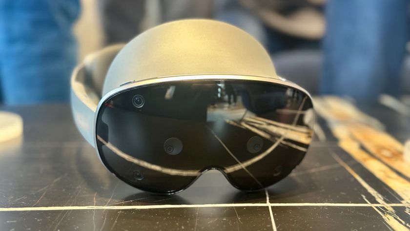 A photo of the Samsung Galaxy XR headset sitting on a table, focused on the front glass.