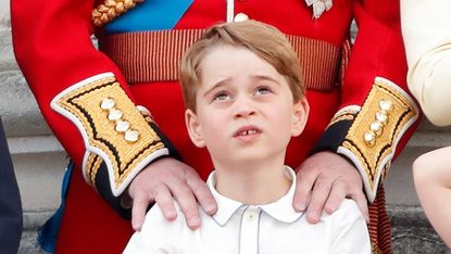 Prince George of Cambridge watches a flypast from the balcony of Buckingham Palace during Trooping The Colour