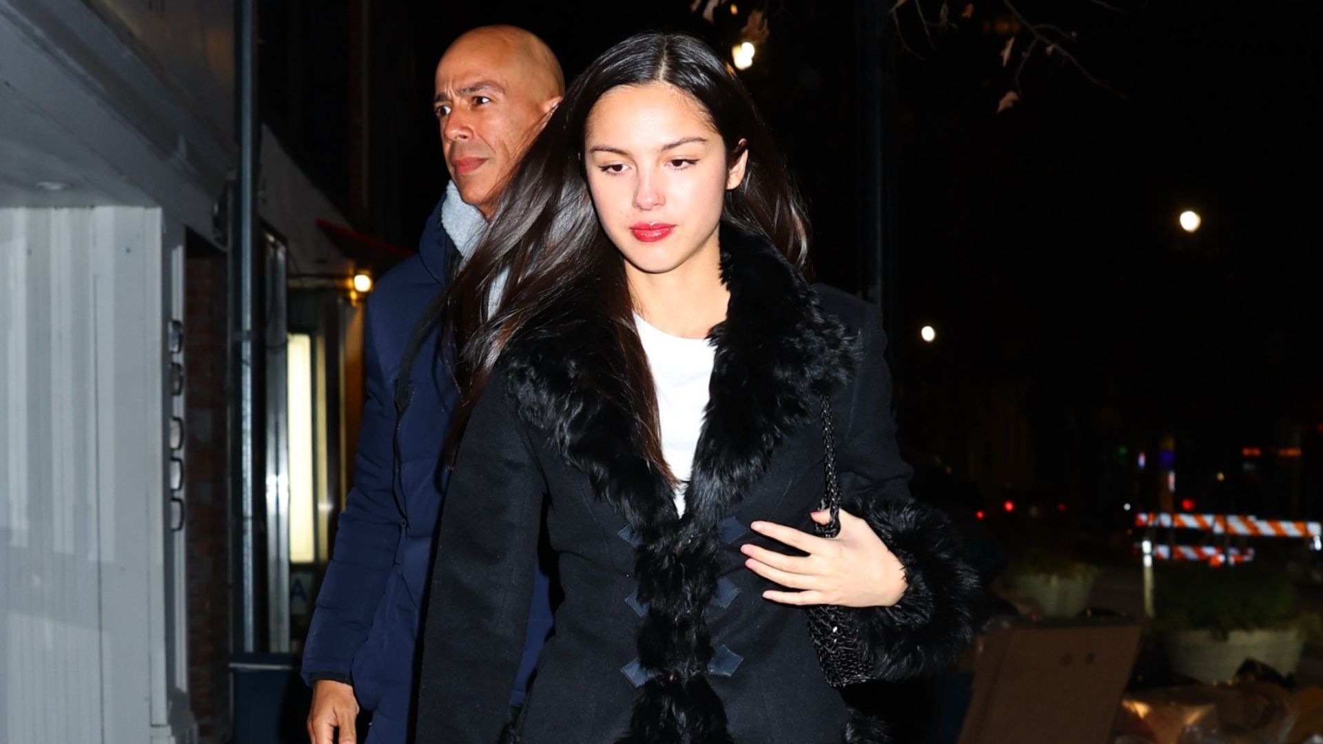 Olivia Rodrigo wears blue cigarette jeans with square-toe boots and a fur-trimmed jacket.