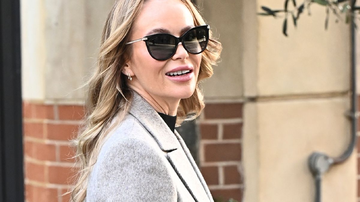 La mini-jupe d'Amanda Holden avec des bottes hautes noires et un blazer assorti donne un look monochrome incroyablement chic