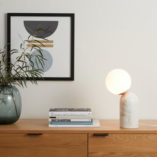 A marble-effect table lamp on a sideboard