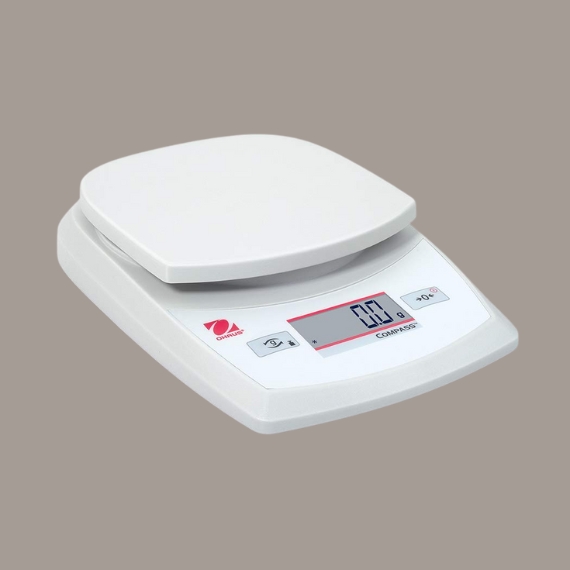 A white, chrome, and red scale sitting against a brown background.