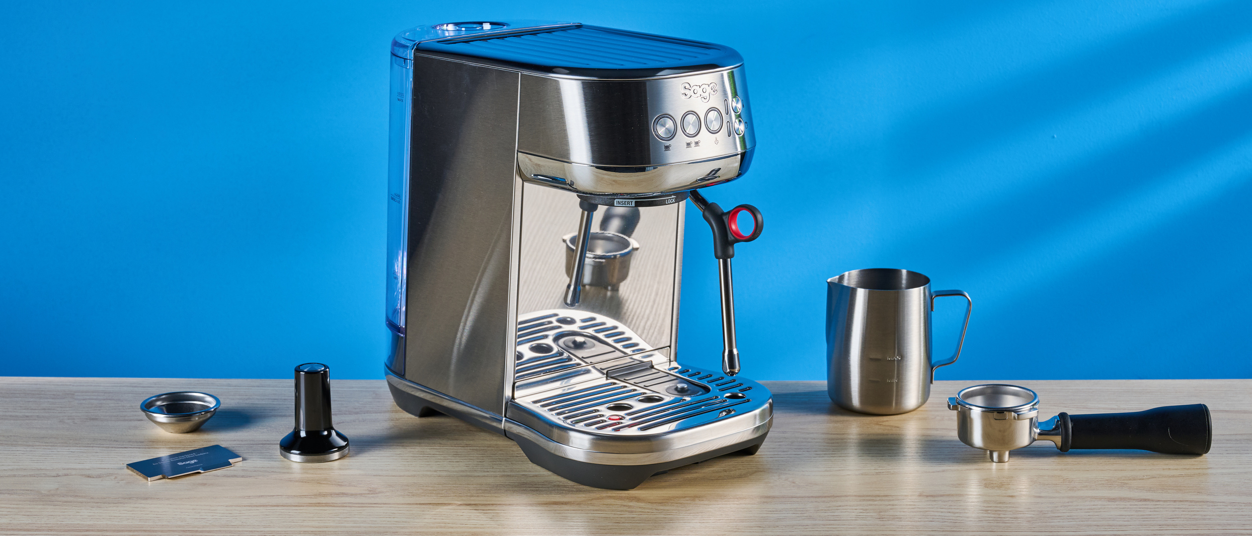 the breville bambino plus / sage bambino plus in stainless steel silver photographed against a blue background shown with its accessories including milk jug, tamper, portafilter, and shown in use extracting espresso