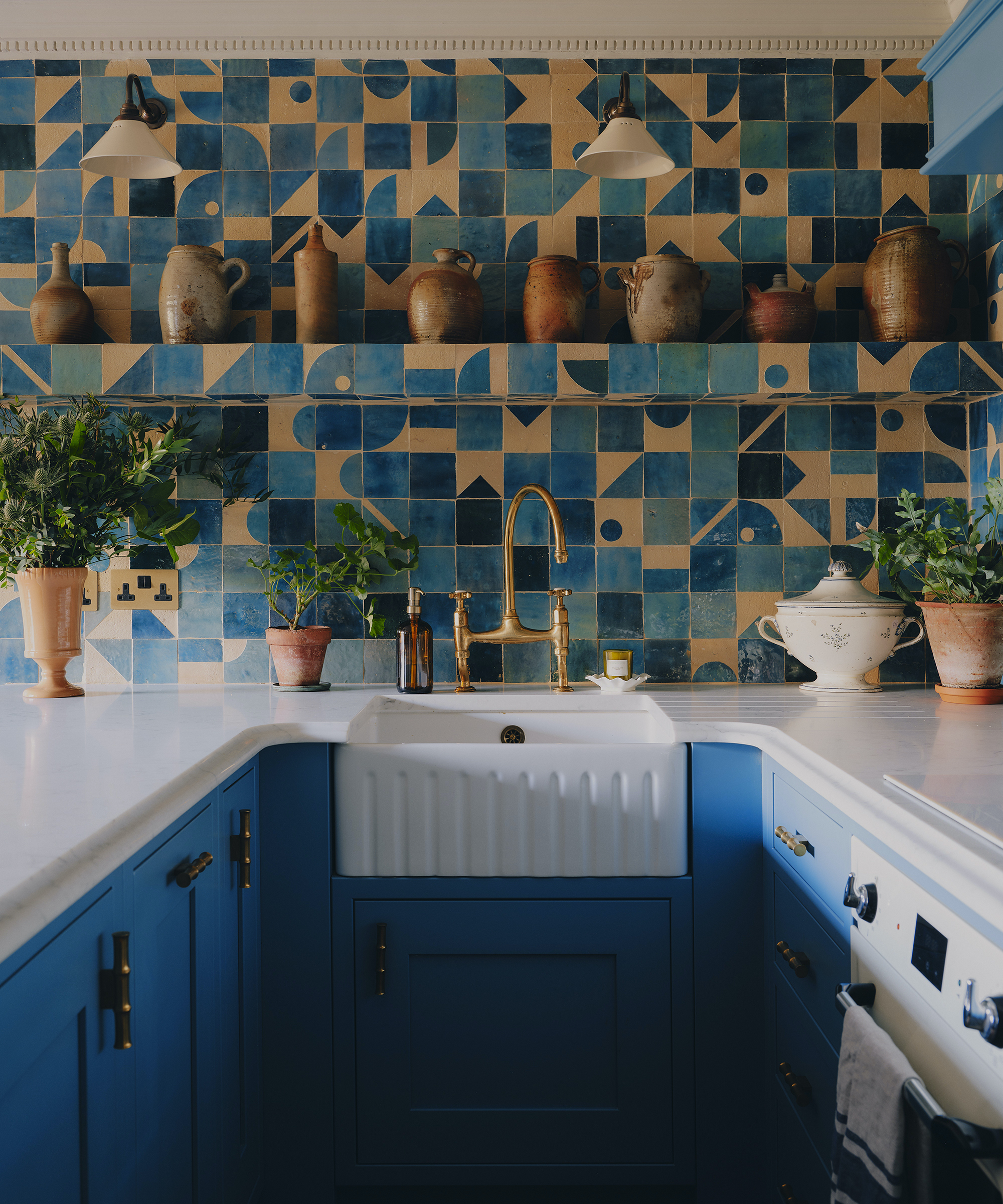 blue kitchen with white worktop and blue and cream tiles