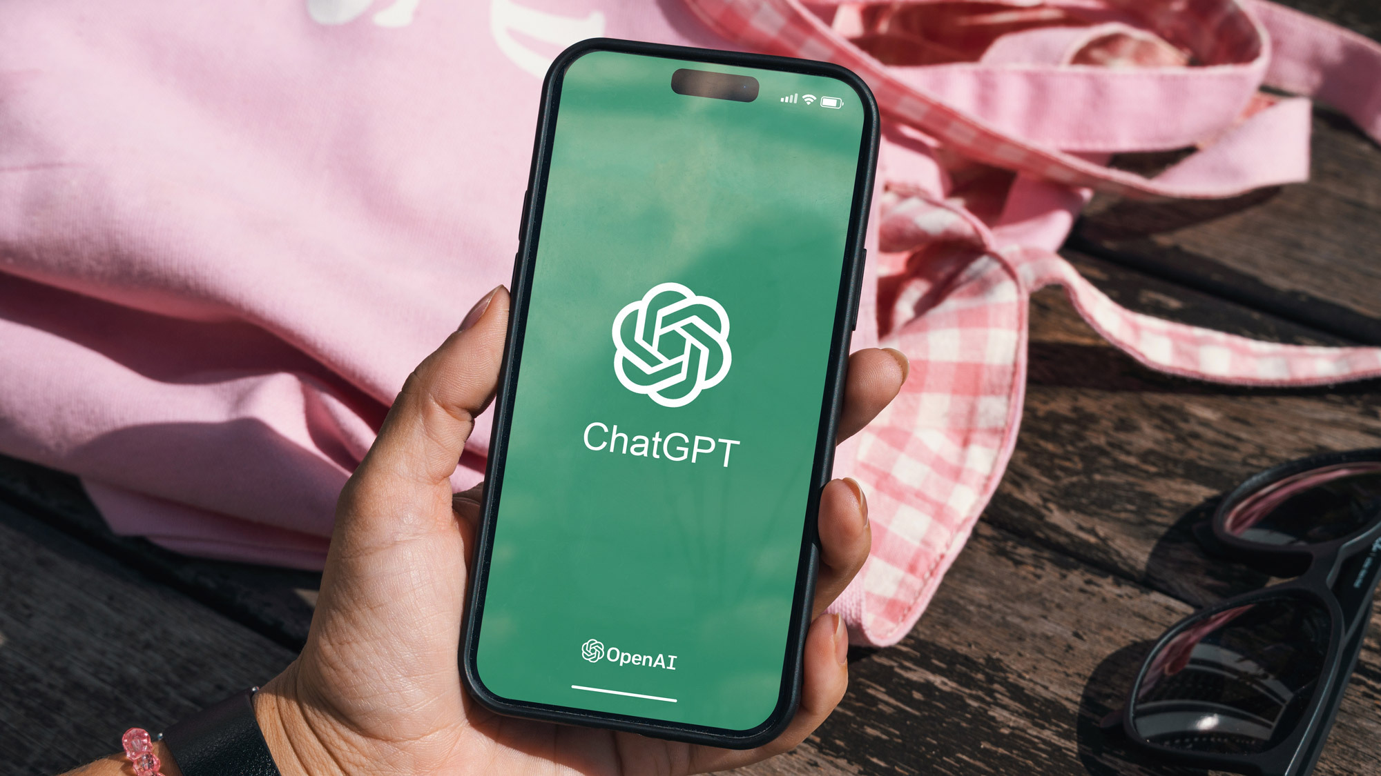 Holding phone with ChatGPT logo