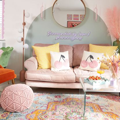 living room with pink sofa and green painted arch on wall