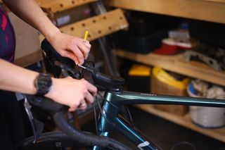Female cyclist adjusting their handlebars