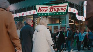 A fake "Keep Buying" sign made to look like the Krispy Kreme Donut sign in Buy Now! The Shopping Conspiracy