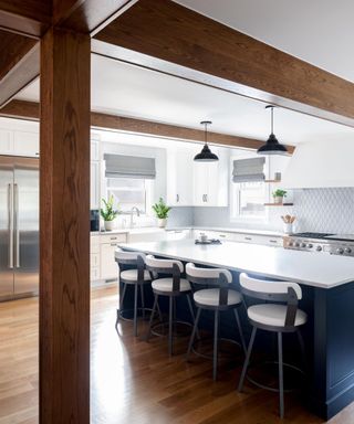 A white kitchen with wooden flooring a wood beams