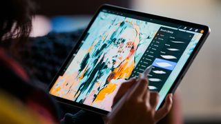 Best Procreate tutorials; a person draws on an iPad