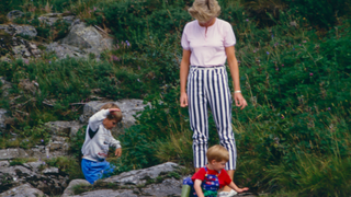 Diana, Princess of Wales, Prince William, and Prince Harry play on the banks of the River Dee, near Balmoral Castle.during a Summer vacation, on August 18, 1987, in Balmoral, Scotland