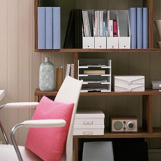 office with organized shelf with files and table with chair