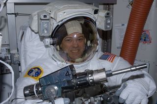 NASA astronaut Ron Garan checks out tools in the International Space Station's Quest airlock prior to the July 12, 2011, spacewalk he performed with crewmate Mike Fossum (not pictured).