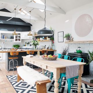 grey and white dining are awith pale wooden table and grey ceiling light