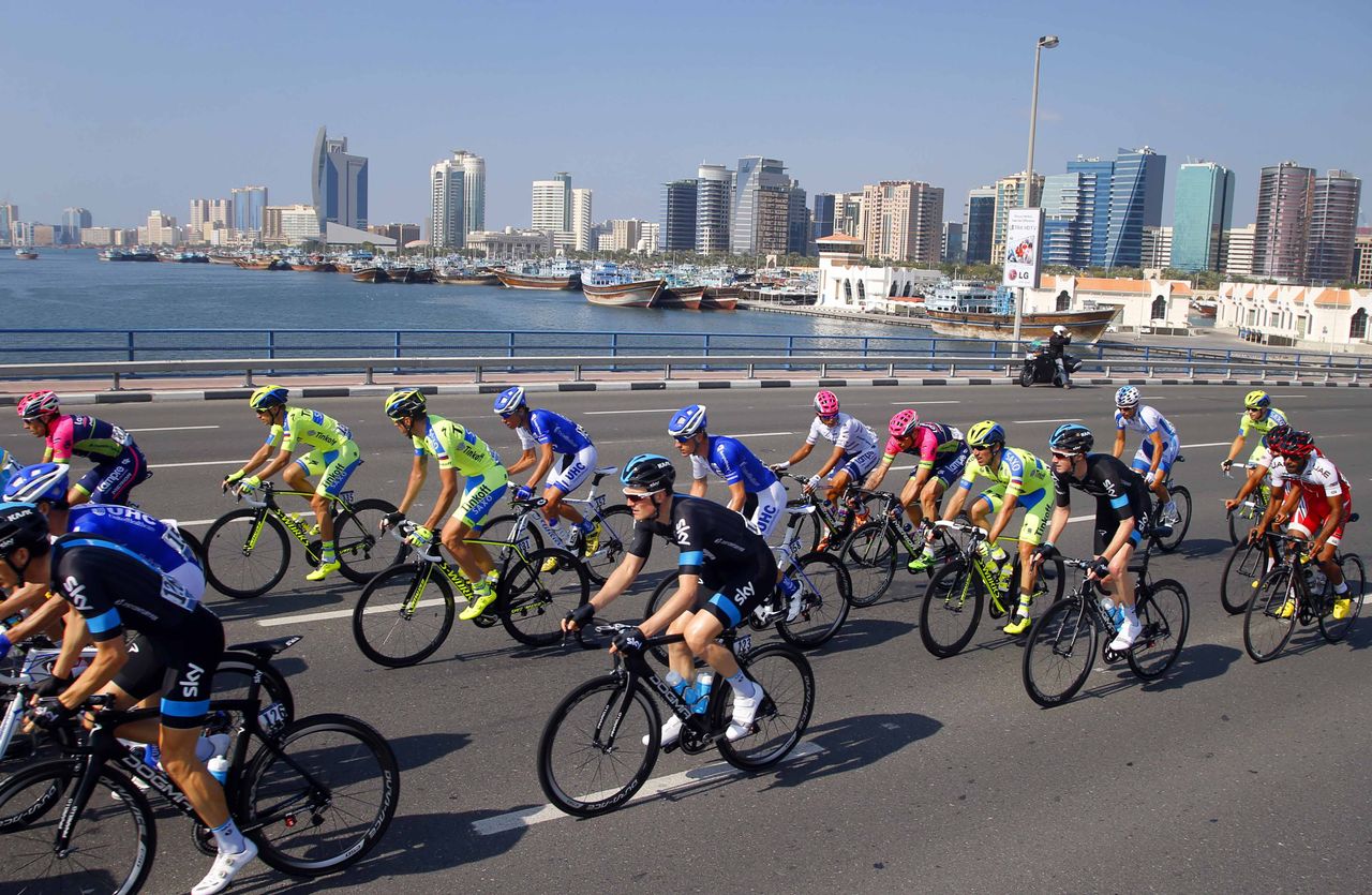 The peloton races against the Dubai skyline.