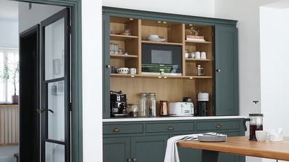 Kitchen with navy built-in open pantry.