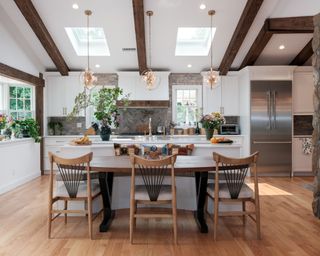 Farmhouse open style kitchen with three spindle back black chairs at the island