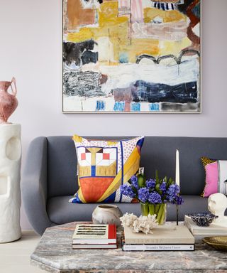 eclectic living room with a hint of pink, gray sofa, artwork, bright colors,