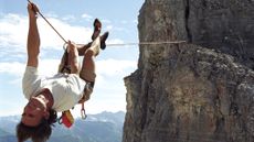 Canadian Rockies, man upside down on a Tyrolean traverse.
