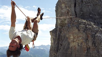Canadian Rockies, man upside down on a Tyrolean traverse.
