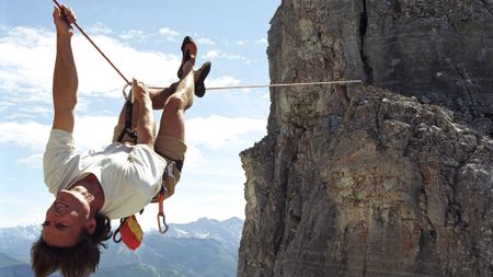 Canadian Rockies, man upside down on a Tyrolean traverse.