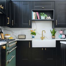 Black painted kitchen cabinets with gold hardware, decorated kitchen worktops