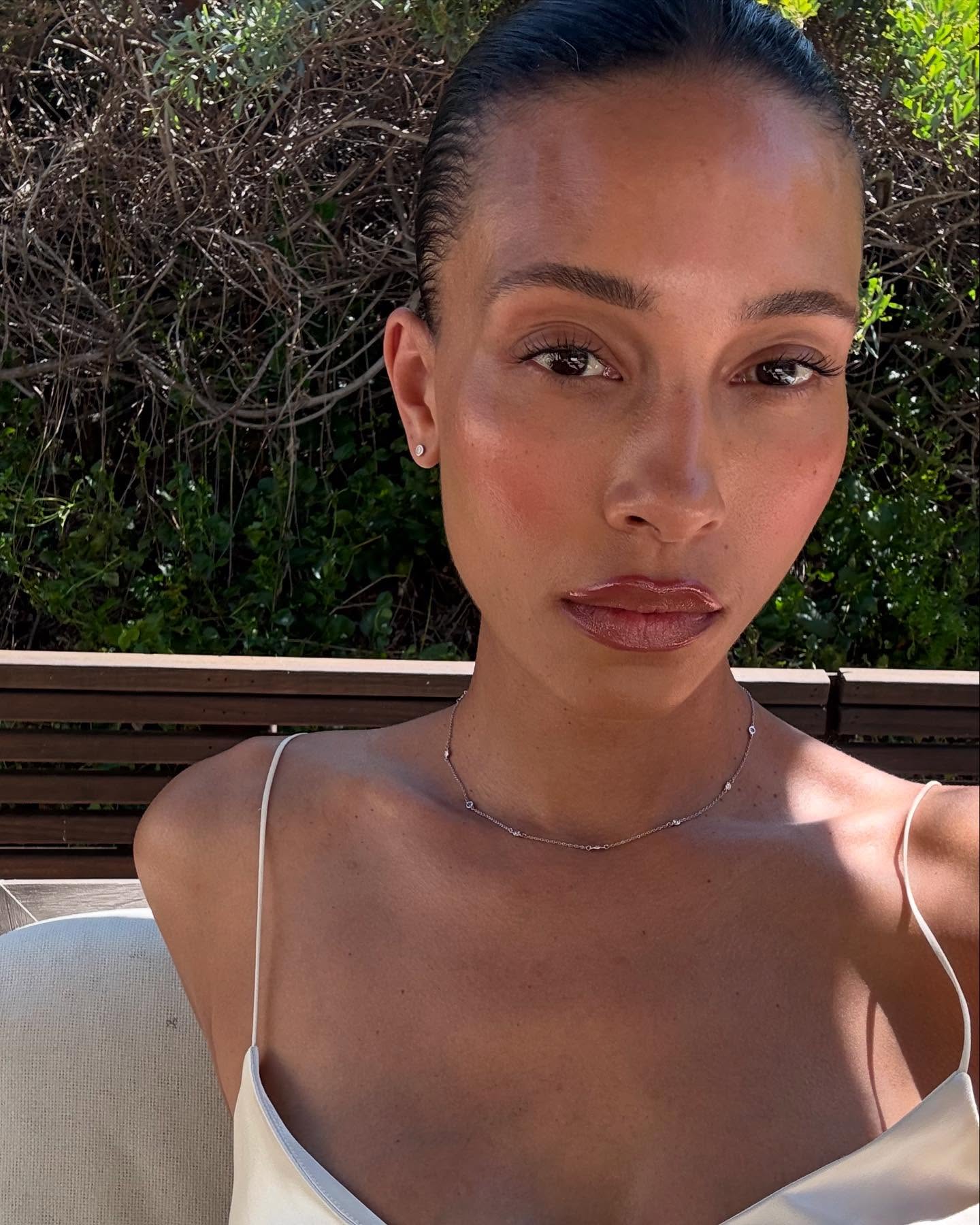 @tylynnnguyen taking a selfie in the sunshine with glowing skin