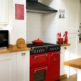kitchen area with red cooker and white wall