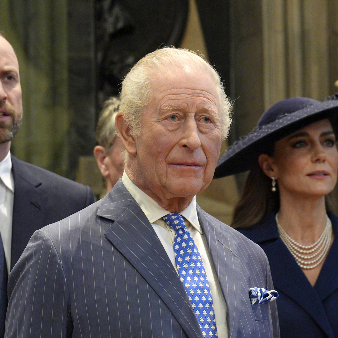 King Charles wears a pinstripe suit and has white gray hair and bloodshot eyes