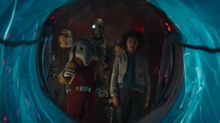 KB, Neel, droid SM-33, Fern and Wim (L-R) look out of a port in a spaceship in "Star Wars: Skeleton Crew".