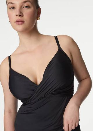 A close up of a model wearing a black tankini top from M&S. 