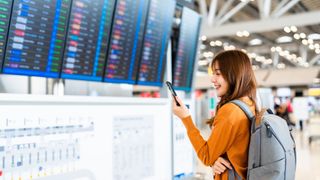 woman in an airport looking at her cell phone