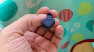 Our reviewer showing the Jabra Elite 4 Active's multifunctional button