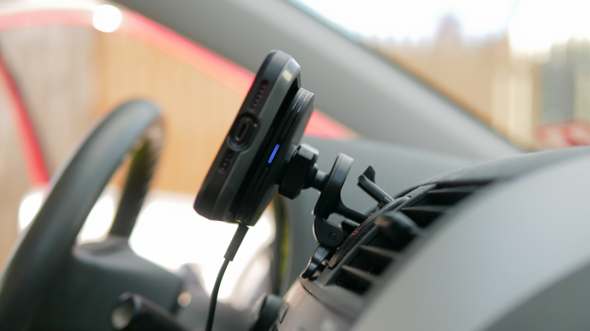 ESR HaloLock MagSafe Car Charger attached to vent clip in car with iPhone.