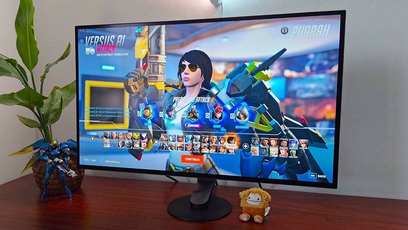 Sony Inzone M10S monitor on woodgrain desk with Overwatch 2 menu on screen and Pharah selected