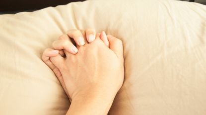 couple holding hands in bed during sex 