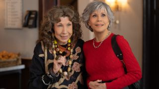 Lily Tomlin and Jane Fonda standing together smiling in Grace and Frankie.