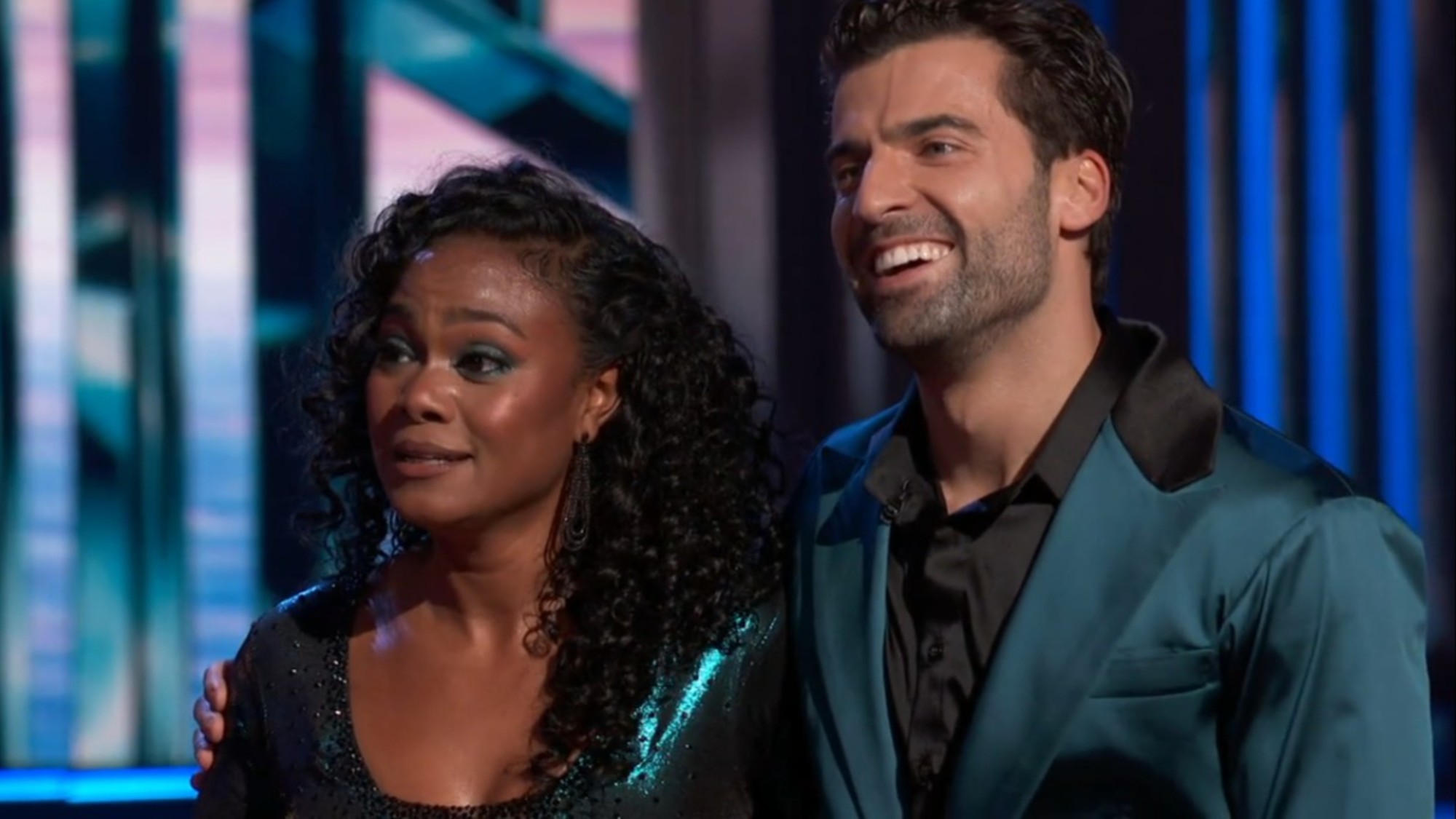 Jan Ravnik and Tatyana Ali smiling as wait for scores in Dancing with the Stars.