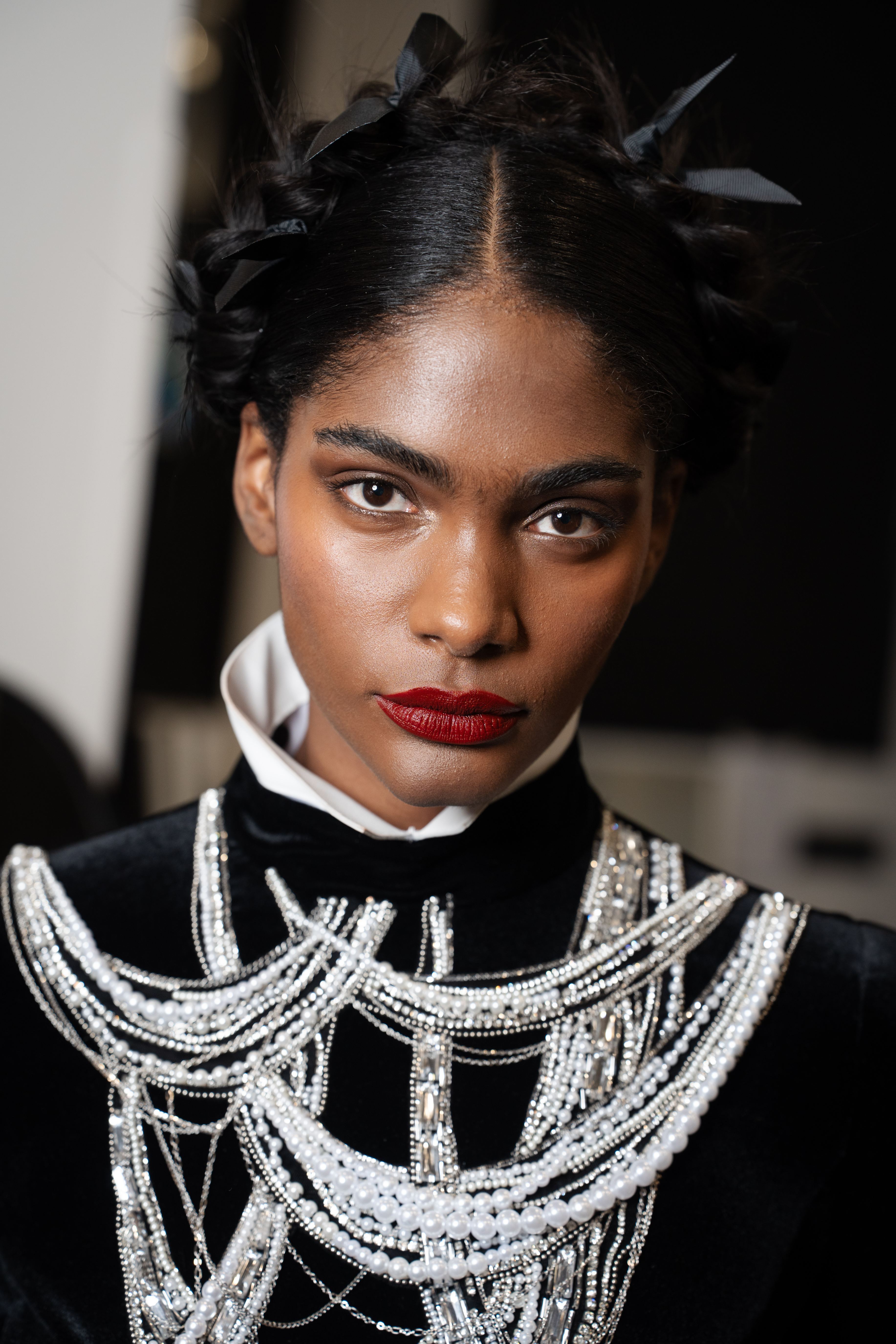 a black woman with dark hair styled in a braided updo backstage at a fashion show