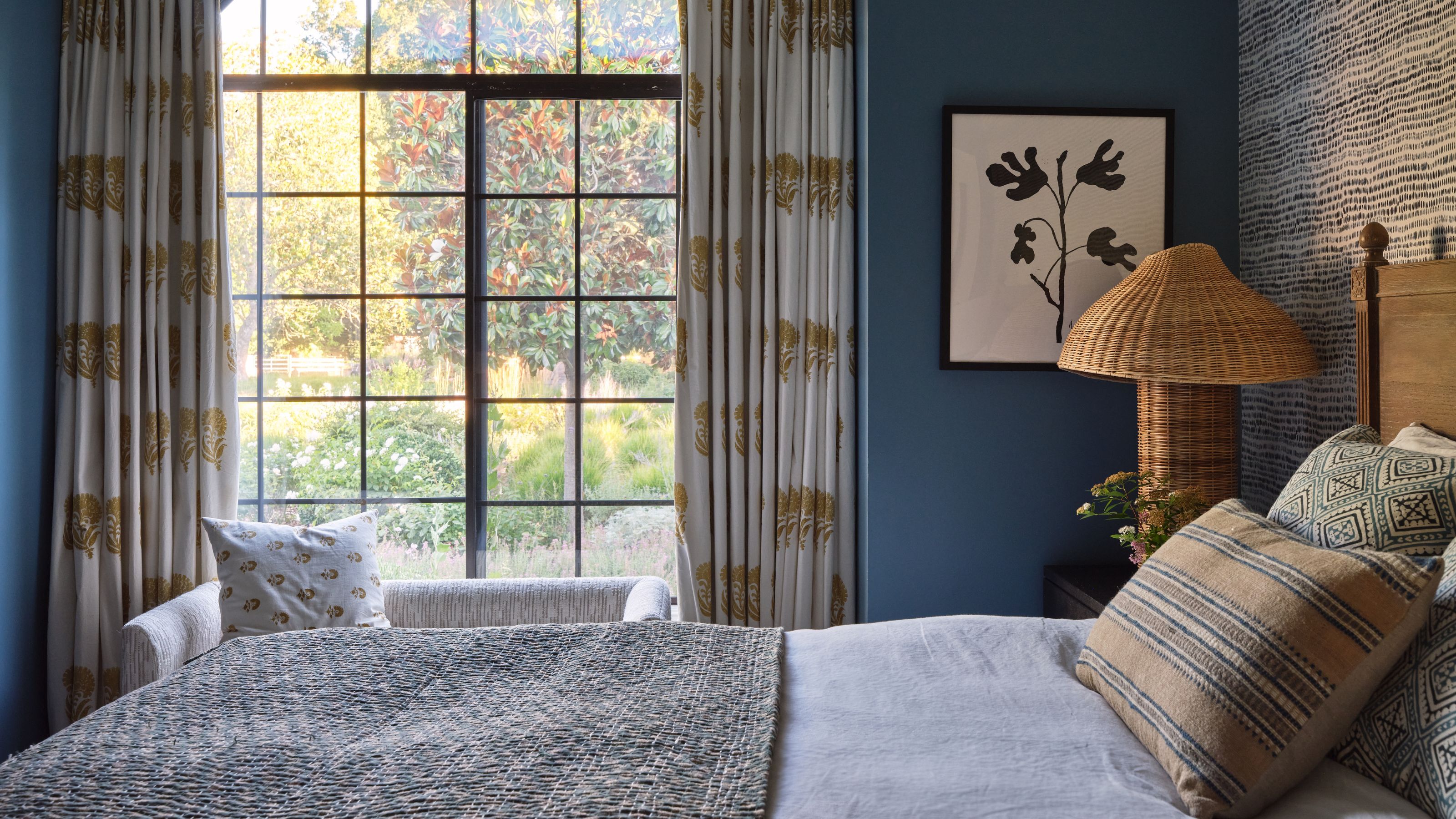 a blue painted guest bedroom in Sonoma with views outdoors and touches of wood and wicker