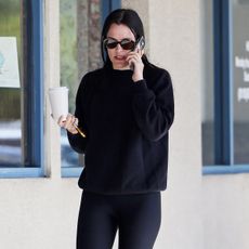 Riley Keough wearing a black top and black leggings with Birkenstock Gizeh sandals 