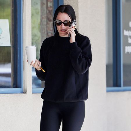 Riley Keough wearing a black top and black leggings with Birkenstock Gizeh sandals