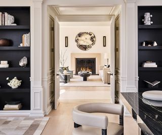 home office with black built-in shelving around ornate paneled doorway