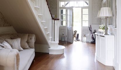 Hallway with wooden chevron flooring and a built in bookcase.