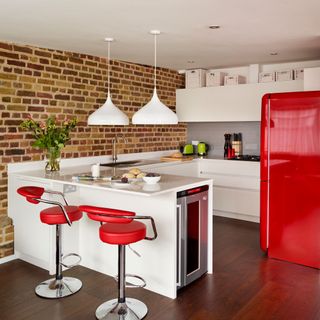 kitchen with white worktop and red fridge