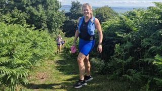 Sarah Finley wearing running vest on green trails while monitoring blood glucose levels