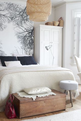 a white bedroom with build-in wardrobe and mural wall