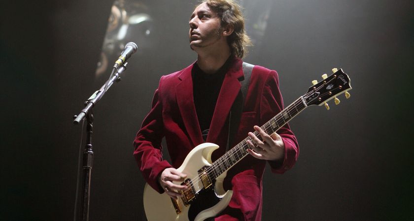Daron Malakian of System of A Down wears a red blazer, black shirt and plays his white Gibson SG onstage in 2005.