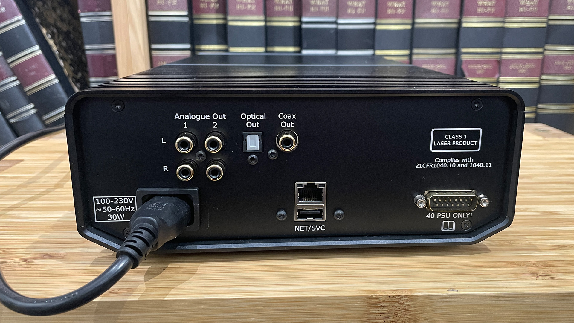 Cyrus 40 CD CD player on wooden hi-fi rack in front of bookcase showing rear connections